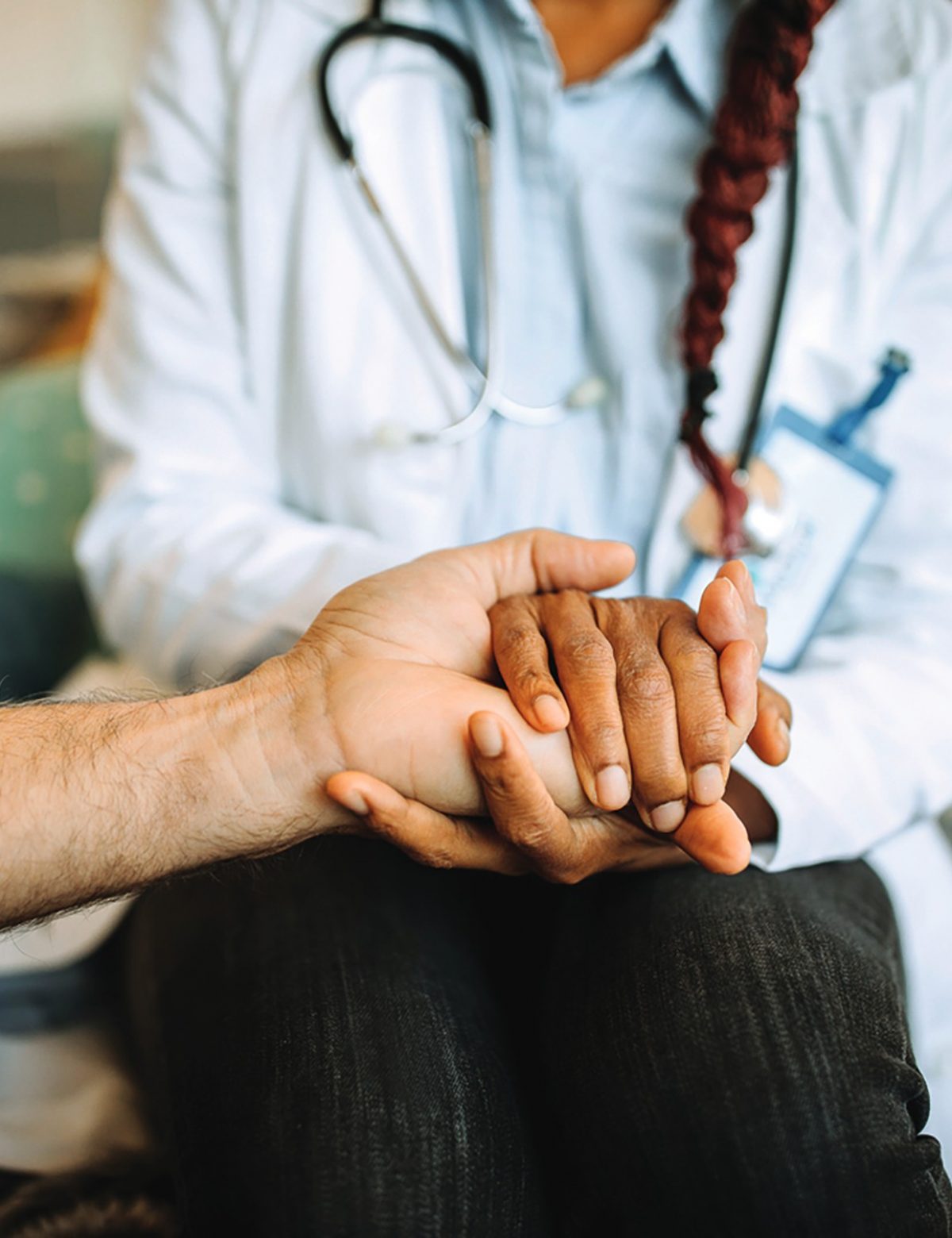 A doctor compassionately holding a patient's hand, offering comfort and support.