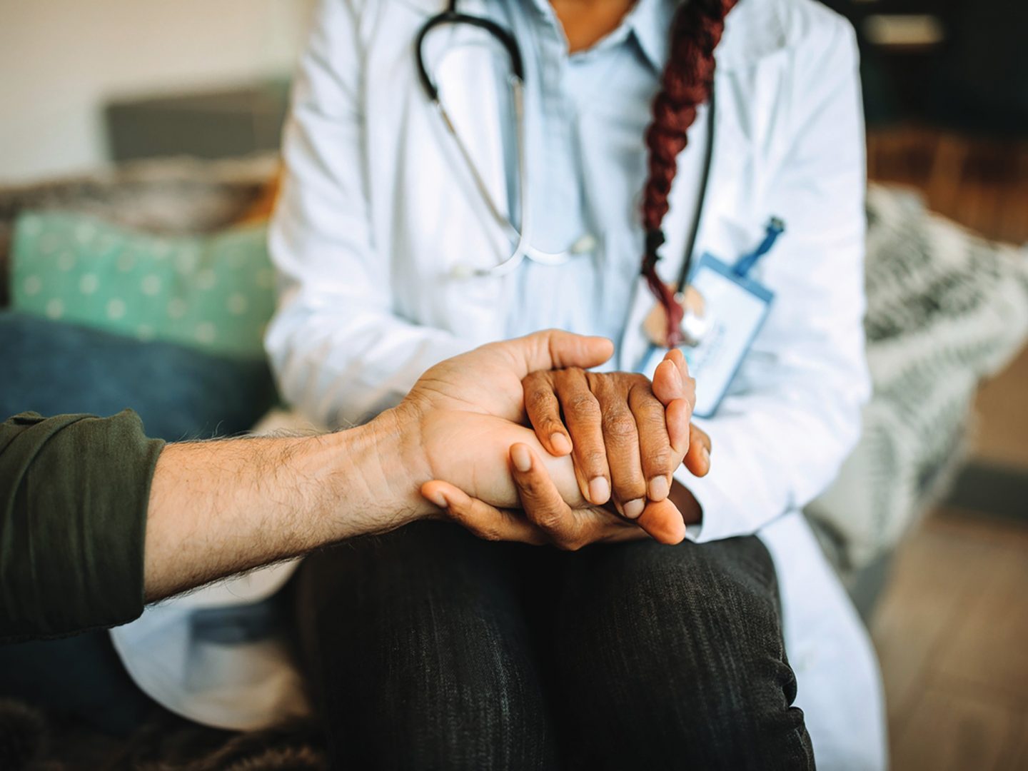 A doctor compassionately holding a patient's hand, offering comfort and support.