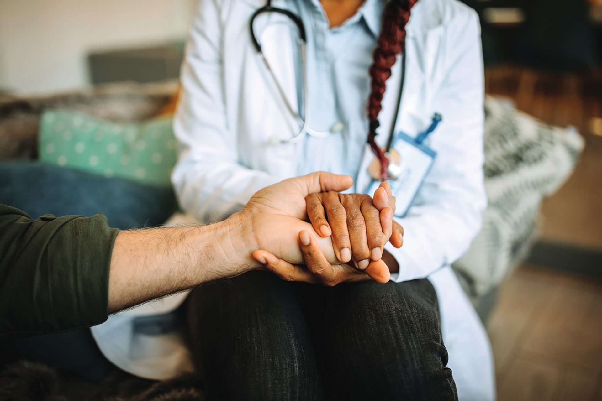 A doctor compassionately holding a patient's hand, offering comfort and support.