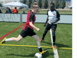 Emma Bellante, wearing a red and black jersey, kicks a soccer ball while a player in a white and black jersey defends during a match at the Canadian Street Soccer Association’s national tournament in Mississauga.