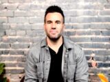 A Caucasian man sits in front of a camera