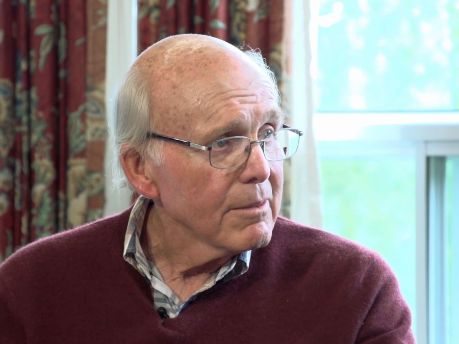 a senior Caucasian man with glasses and a sweater