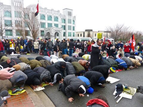 people lay their heads on the ground outside to pray