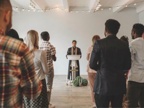 Minister stands at pulpit in front of congregation