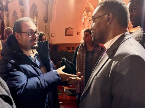 man in glasses talks to another man