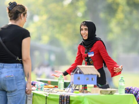 Volunteer Sadaf Saberi smiles as she explains some traditional Myanmar clothing and cultural objects at the Refugee Highway event