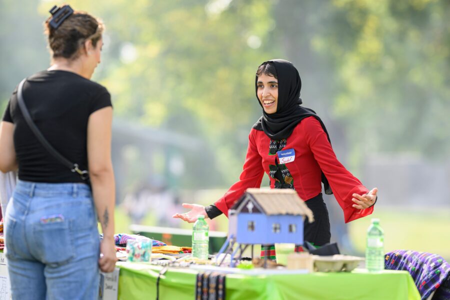 Volunteer Sadaf Saberi smiles as she explains some traditional Myanmar clothing and cultural objects at the Refugee Highway event